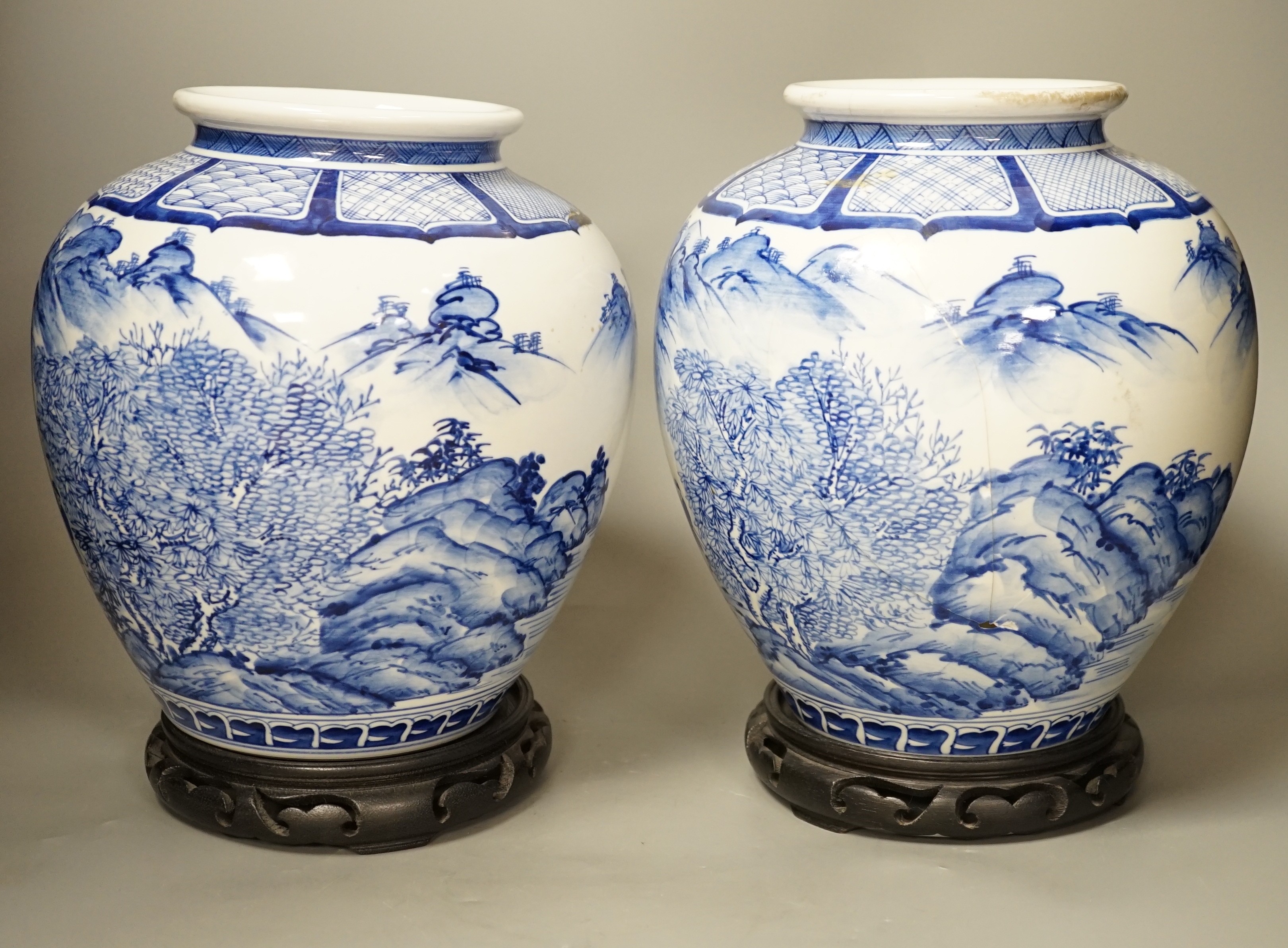 A pair of large Japanese blue and white vases, on wood stands, 26cms high of including stand.